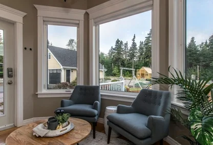Bright sitting area with large windows overlooking lush greenery in Torbay home